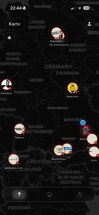 The LQΛL map screen on a phone — a dark map of Germany, Austria and Switzerland with bikepark logo pins at Hahnenklee, Erbeskopf, Osternohe, Todtnau, Adelboden-Lenk, Saalbach and others.